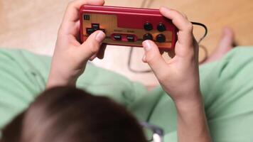 Child playing retro games using controller at home video