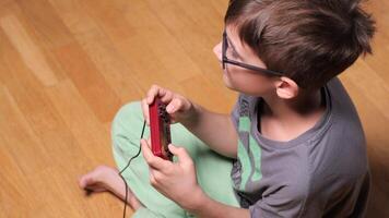 Young boy playing with retro game console at home video