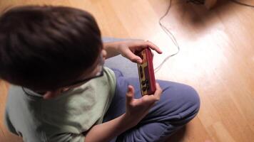 Child playing with a retro game console at home video