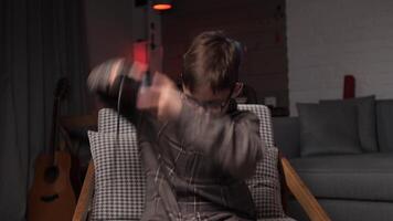 Boy holds game console joystick and hits controller with his hands in anger video