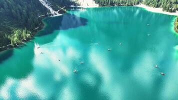 Aerial view of canoeing on turquoise lake surrounded by mountains video