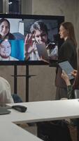 Several employees in the office were calling colleagues remotely during a meeting via at the company. Vertical. video