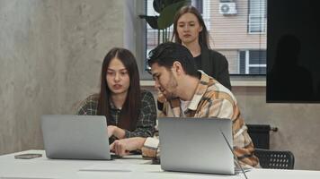 Colleagues work in office, dealing with paperwork. boss brings lot of documents, which annoys employees, as it means that they will have to stay late to finish their work. video