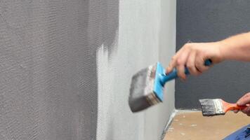Skilled hands apply a fresh coat to a quartz wall, showcasing techniques and tools during the renovation process in a contemporary setting video