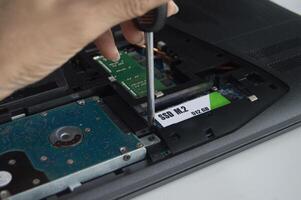 Side view of technician installing M.2 SSD hard drive. photo