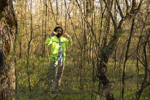 Search party leader guiding the team into the woods area to find evidence during manhunt mission, searching for a missing person. Rescue squad yelling victims name, lost in the woods. photo