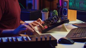 Audio engineer working with soundboard to create the perfect sounds for his new songs, recording and mixing audio. Music producer adjusts volume levels during recording sessions. Camera A. photo