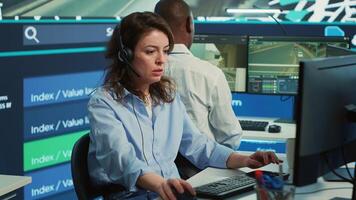 Diverse operators giving updates on order tracking to clients, working with surveillance CCTV footage in the CCTV and satellite map to ensure fast delivery. Employees in control center. Camera A. photo