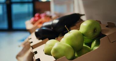 Locally grown ripe fruits and vegetables sold at zero waste shop, nonpolluting ethically sourced produce in crates. Empty supermarket with natural merchandise. Handheld shot. Close up. photo