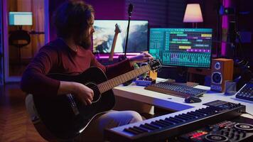 Musician trying to tune the sound of his guitar in home studio, adjusting knobs before playing tunes and recording on daw software. Advanced mixing and mastering techniques. Camera B. photo