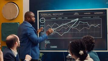 African american project manager analyzing infographics to evaluate supply and demand, working with his team to find ways of increasing corporation income and develop internationally. Camera A. photo
