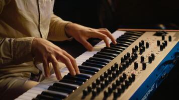 Talented artist performing in control room at studio and recording music for new album, working with mixing console and motorized faders. Musician composing new tracks on technical gear. Camera A. photo