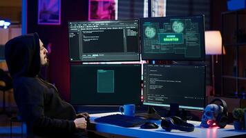 Hacker happy after successfully doing computer sabotage using ransomware, seeing access granted message. Cybercriminal successfully gaining access to victim data, demanding ransom money, camera A photo