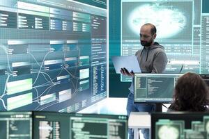 Cyber security team conducting cyber surveillance in a governmental control room. Experts group hacking activities, malware protection and data breach prevention in high tech agency. photo
