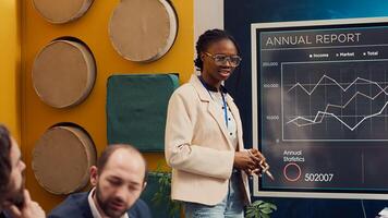 Business employee doing a presentation with project updates and timelines to ensure progress, explaining allocated resources and strategic objectives. Coworkers attend a briefing meeting. Camera A. photo