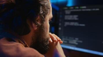 Programmer in home office concentrating on finding bugs while doing coding on computer, extreme close up shot. IT admin frowning while looking at screen, confused by errors in lines of code, camera B photo