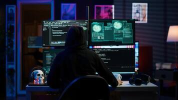 Hacker arriving in underground HQ, ready to start coding malware designed to exploit network backdoors and bypass security measures such as logins and password protections, camera A photo