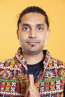Portrait of anxious man putting hands together, doing gesturing, requesting help, studio backdrop. Close up shot of worried person in need of assistance soliciting aid to solve problem photo