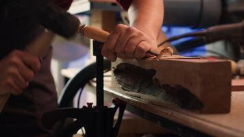 Experienced woodworker shaping raw timber using chisel and hammer, enjoying diy hobby. Woodworking professional in studio shaping wooden pieces with tools, making wood sculptures, camera A close up photo