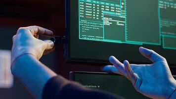 Hacker doing illegal activities in secret underground base, uploading USB flash drive containing data obtained from victim after tricking it into installing ransomware program, camera A photo
