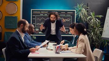 Startup team analyzing success metrics and key performance indicators to follow updates and establish changes, status update meeting. Coworkers measure progress towards strategic goals. Camera B. photo