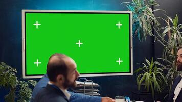 Marketing team meeting in a boardroom with isolated TV display, working together to improve the organization public image and social media presence. Business specialists conduct analysis. Camera A. photo