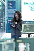Cyber security expert investigates governmental hacking malware attack on big screen, high tech center. Cybercriminal woman hacks computer systems, threatening database protection. photo