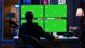 Cybercriminal coding on green screen monitors, developing zero day exploit undetectable by antivirus software. Hacker using mockup PC displays to build script tricking firewalls, camera A photo