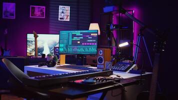 Empty space filled with mixing instruments and electronic tools, soundboard console and mastering panel used for recording tunes. Awd software on pc used in acoustical engineering. Camera B. photo