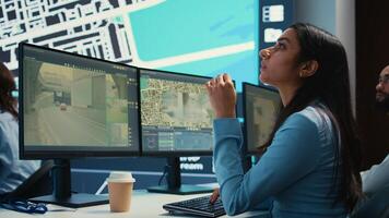 Indian operator transmitting gps coordinates for couriers to deliver orders, following awb information and satellite map to avoid traffic. Employee sending directions and cargo location. Camera B. photo