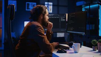 Programmer doing web development during remote job shift in neon lit home office, finishing coding project. IT specialist sitting at computer desk, working on desktop PC, camera B photo
