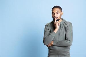 Pensive african american guy acting curious and uncertain about something, thinking about new genius ideas for innovation. Creative doubtful person contemplating for inspiration. photo