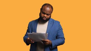 Accountant doing profit analysis for company, throwing files in air, feeling overworked, studio background. African american worker doing financial budgeting, having outburst, annoyed by too much work photo