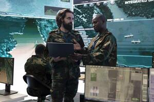 Soldiers team develops new operational plans for a new field mission, preparing important intelligence in military command center power base. Staff tracking enemy servers or headquarters. photo