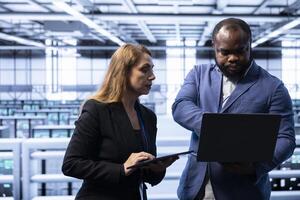 Data center teamworking colleagues ensuring safety and security of database. Cybersecurity team coworkers in server farm preventing unauthorized access posing risks for company photo