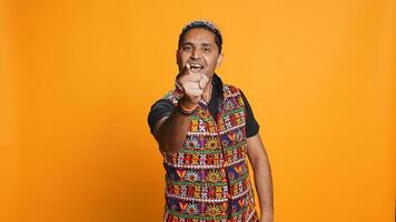Portrait of narcissistic cheerful indian man celebrating and bragging, showing arrogance. Satisfied person boasting about achievement, cheering and gesticulating, studio background, camera B photo