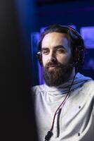 Man playing videogames in front of subscribers during livestream, focused on defeating enemies. Close up on pro gamer streaming game, wearing headphones, doing online stream photo