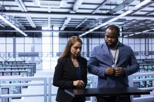 Engineers in data center tracking network traffic and activity using augmented reality, installing and configuring software updates. Coworkers performing database backups using AR holograms photo
