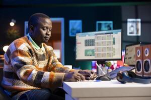 Financial advisor writing a posit it memory note to work on revenue balance, studying annual statistics to create a report for his CEO. Black accountant evaluating legal infographics. photo