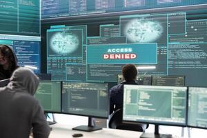 Disappointed team of governmental hackers failing to access database and servers in high tech office, work with big screen to steal passwords for hybrid warfare. Frustrated experts. photo