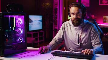 Panning shot of streamer talking with audience, filming tutorial on how to defeat enemies in multiplayer game. Professional gamer teaching fans competitive esports winning strategies photo