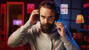 Professional gamer chatting with teammates while engaging in online competitive multiplayer match using cutting edge gaming setup. Man communicating with internet friends playing videogames, zoom out photo