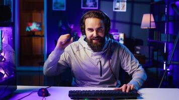 Gamer in neon lit home feeling upset after losing against opponent in online esports competition. Player punching desk in frustration after being defeated by enemy in videogame internet tournament photo