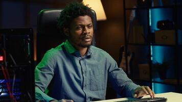 BIPOC man plays intense videogame tournament online during stream with audience, spamming attack buttons. Gamer participating in esports competition during livestream, pressing hard on keyboard keys photo