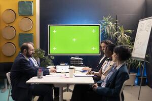 Business team attending brainstorming meeting with mockup screen, sharing insight and generating ideas to obtain more capital for projects. Looking for ways to increase financial potential. photo