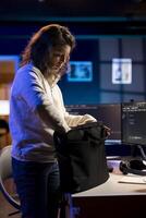 System administrator closing backpack, leaving office after filtering malicious traffic from cybercriminals. Skilled IT professional finishing job shift after being done with preventing malware photo