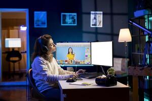 Photographer uses photo editing software on mockup PC display, listening music. Freelancer wearing headphones uses photographs retouching program on isolated screen multi monitor computer setup