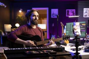 Skilled artist teaching how to play acoustic guitar on internet, creating online tutorial to give assistance with musical instrument. Musician performer explaining accords and notes on each strings. photo