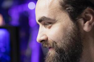 Upbeat gamer unaffected by losing match with teammates while playing competitive esports tournament. Close up of man being optimistic in spite of loss while enjoying multiplayer videogame with friends photo