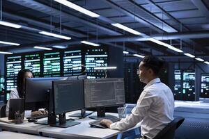 Engineering coworkers in data center looking for firewall misconfigurations affecting servers. IT staff members in server room check systems bottlenecks leading to sluggish data transfer rates photo